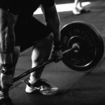 A powerful black and white image of a man deadlifting in a gym, showcasing strength and fitness.